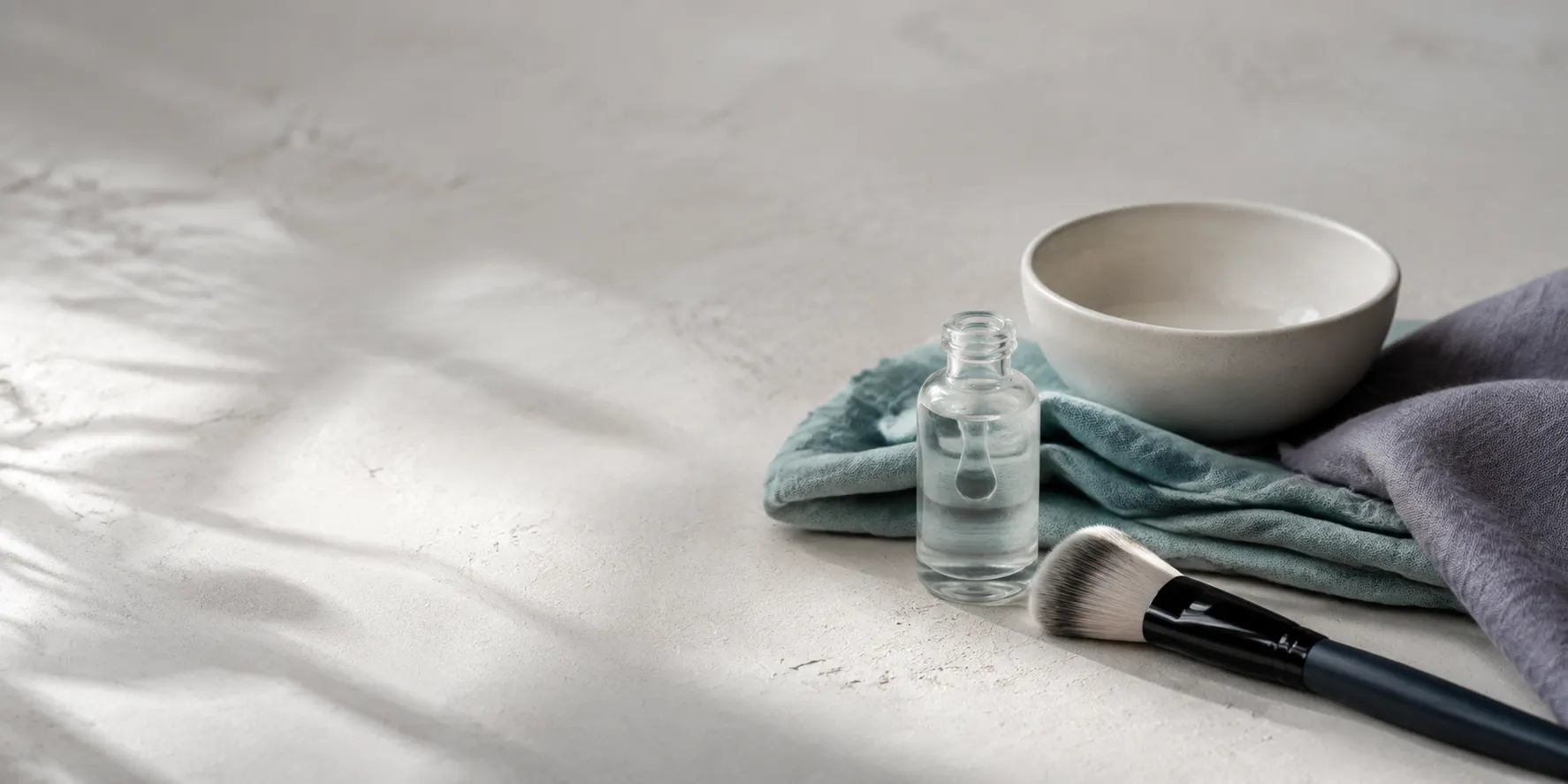 KI-generiertes Stillleben mit Porzellanschale, Leinen, Serumtextur und Make-up-Pinsel